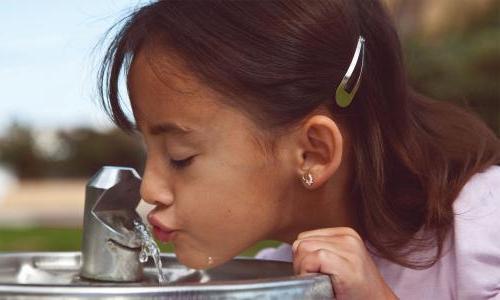 女孩从饮水机里喝水